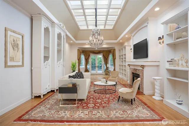 a living room with fireplace furniture a rug and a chandelier