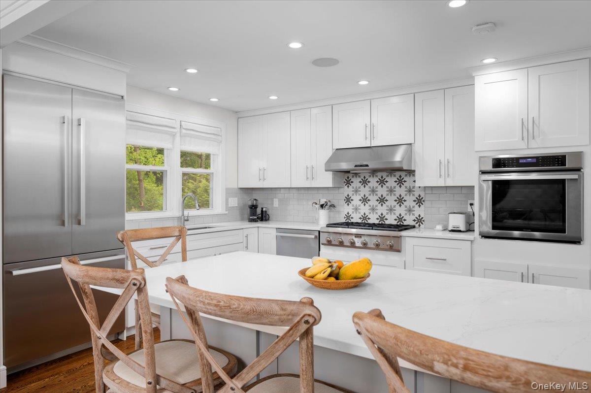 33 Temple Street Harrison, NY 10528 - Photo 13 of 31 a kitchen with a table chairs refrigerator and microwave