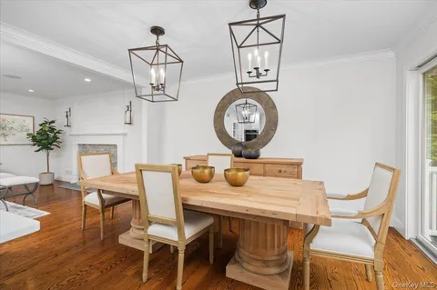 a view of a dining room with furniture a chandelier and wooden floor