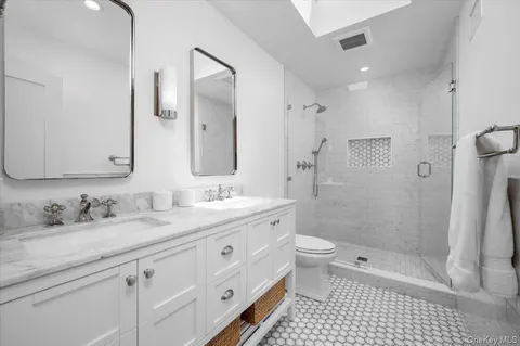 a bathroom with a double vanity sink toilet and shower