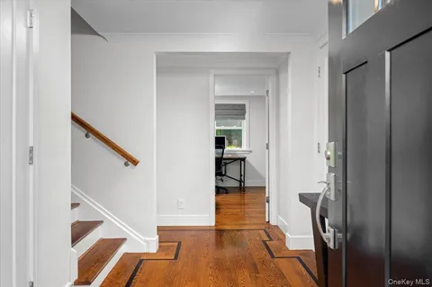 a view of a hallway with wooden floor and staircase