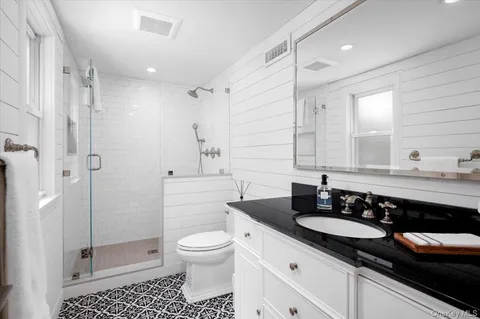 a bathroom with a sink a toilet and shower