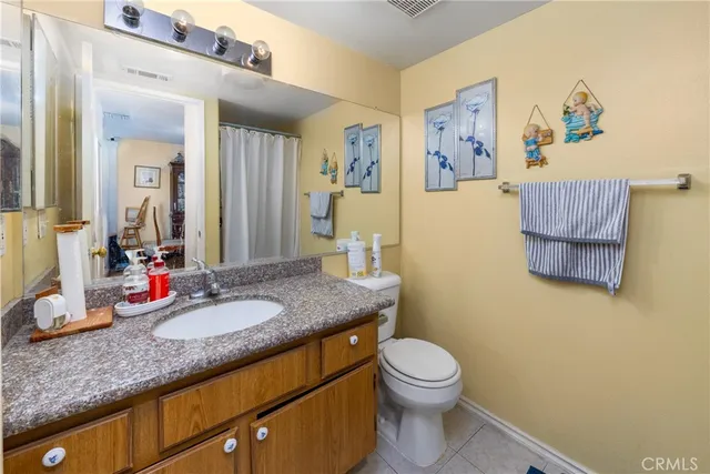 a bathroom with a granite countertop toilet sink and a mirror