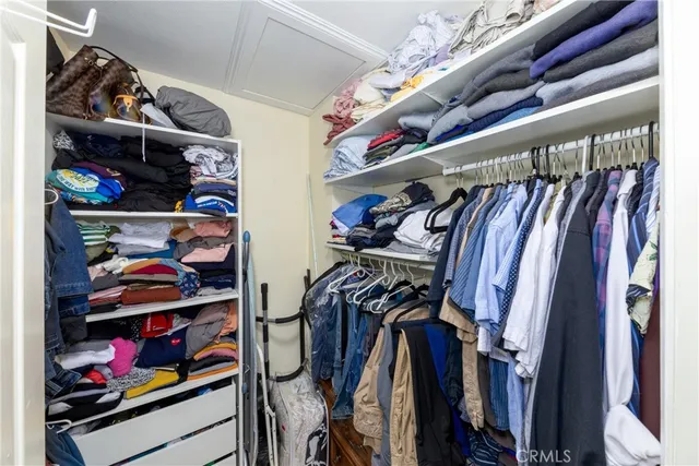 a view of walk in closet with clothes and shoes