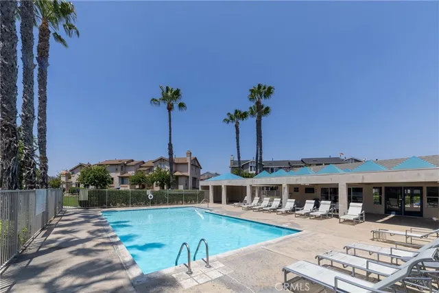 a view of a house with pool and chairs