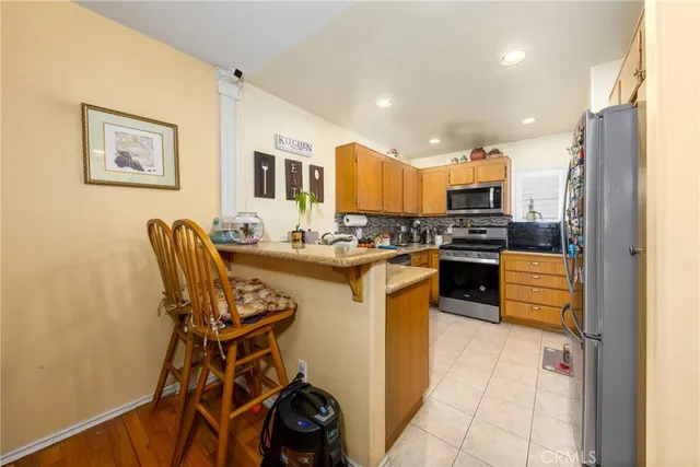 a kitchen with stainless steel appliances kitchen island granite countertop a refrigerator and a stove top oven