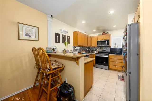 a kitchen with stainless steel appliances kitchen island granite countertop a refrigerator and a stove top oven
