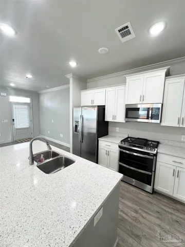 a kitchen with granite countertop a refrigerator and a sink