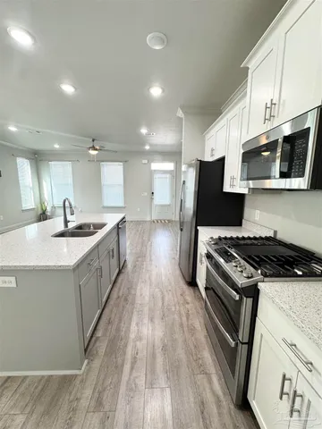 a kitchen with stainless steel appliances kitchen island granite countertop a stove a sink and a microwave
