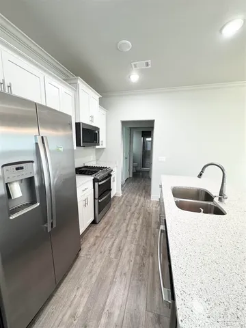 a kitchen with granite countertop a refrigerator and a stove top oven
