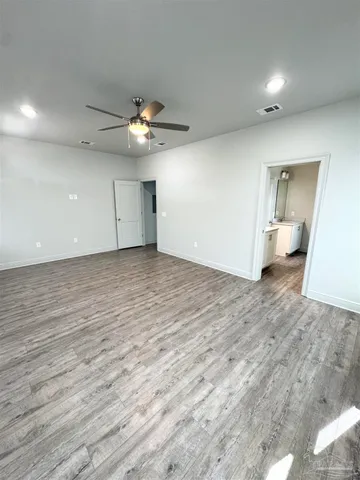 a view of empty room with wooden floor