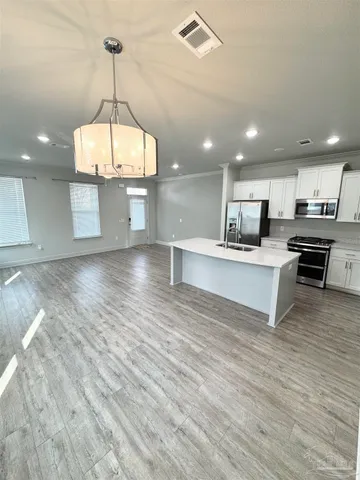 a view of kitchen with sink microwave and cabinets