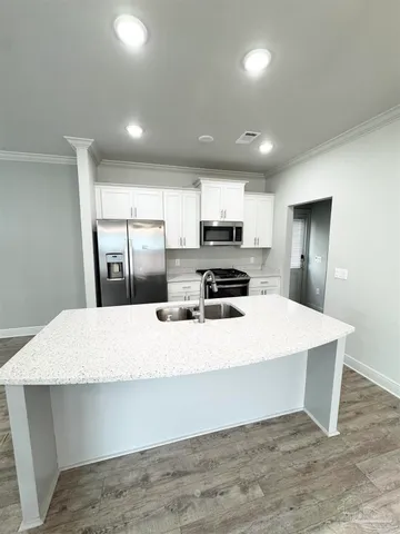 a large white kitchen with wooden floor