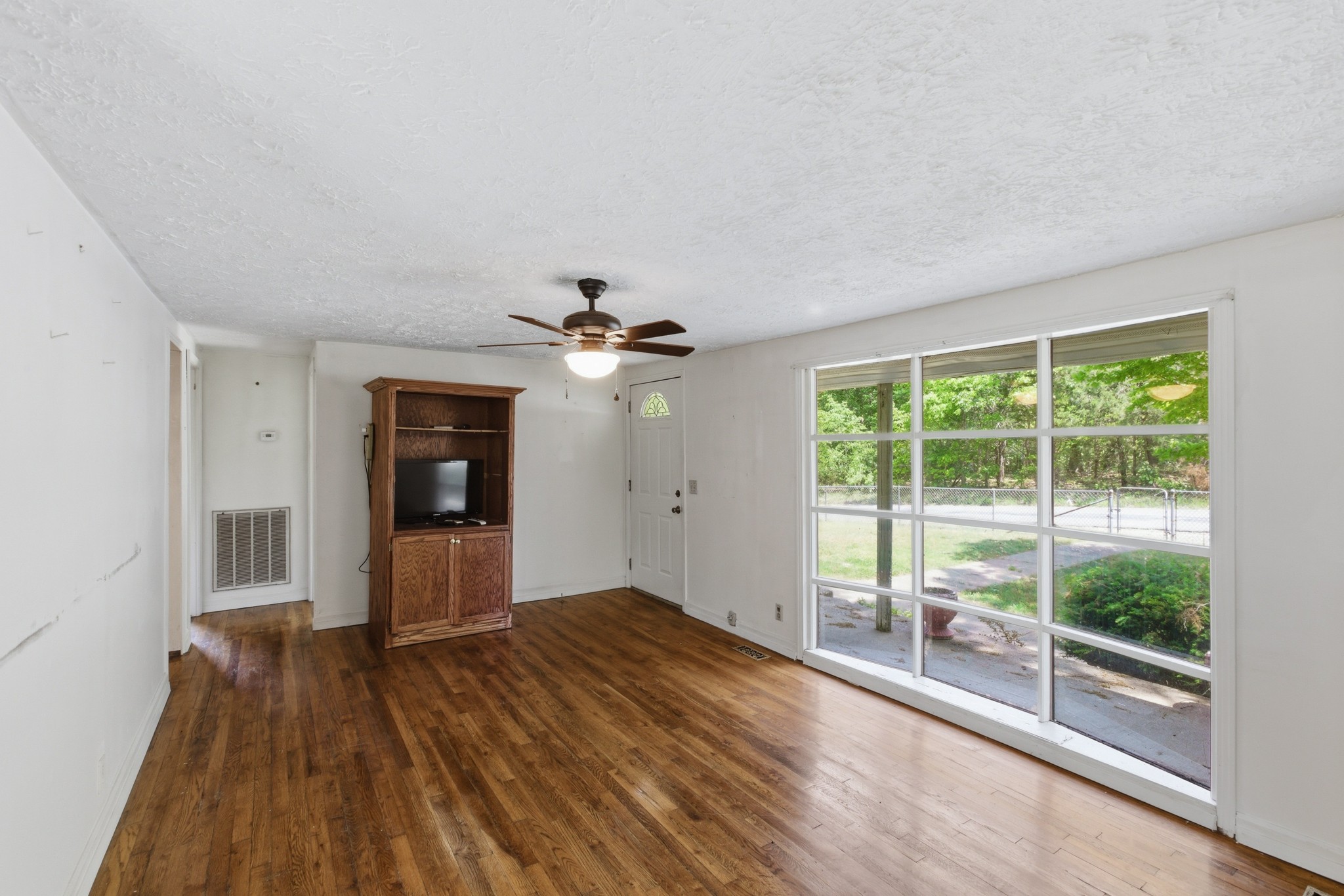 10075 Buckner Ridge Road Bon Aqua, TN 37025 - Photo 13 of 20 a view of empty room with wooden floor and fan