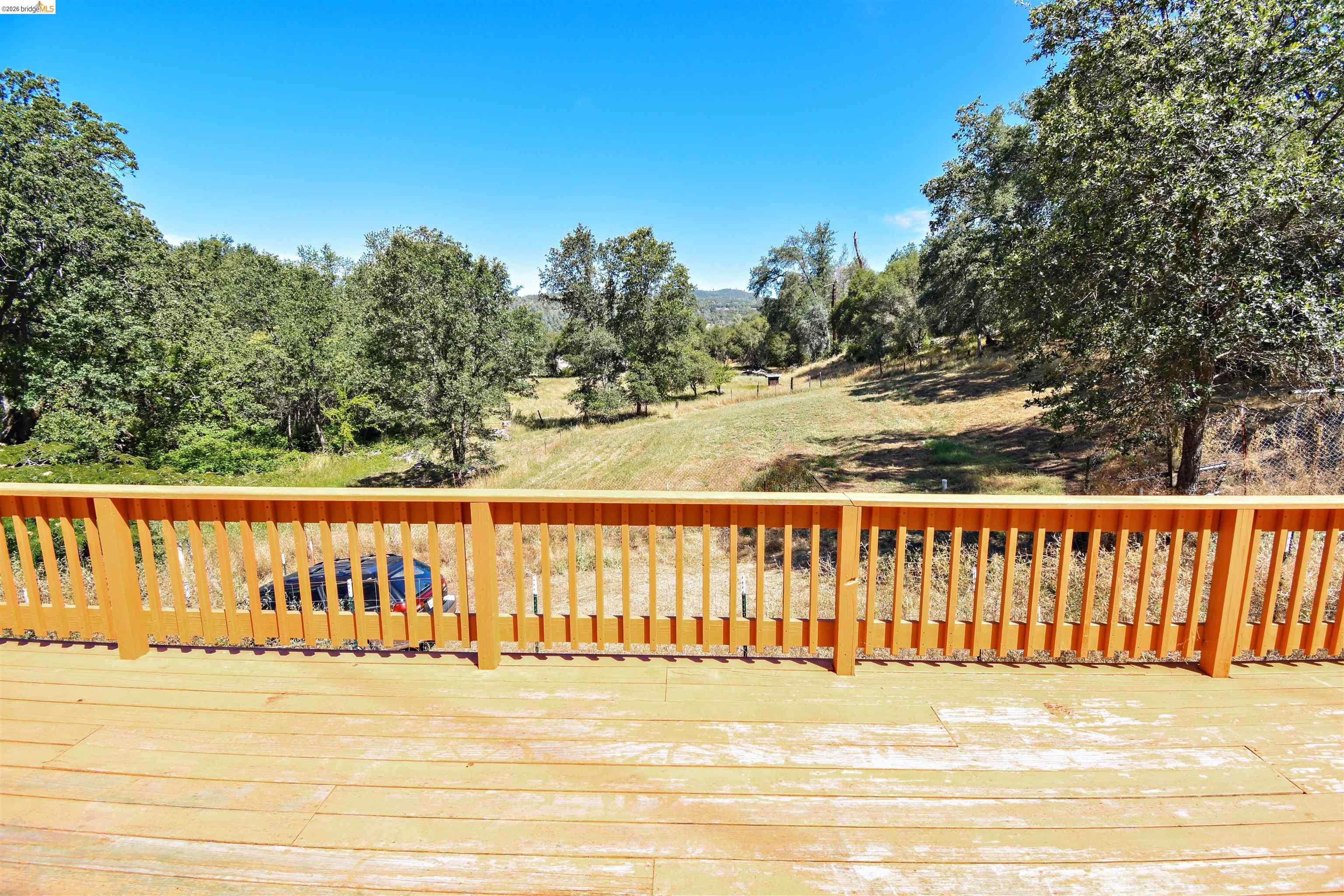 13904 Tuolumne Road Sonora, CA 95370 - Photo 29 of 44 Exterior wood-finish decking with a wood-finish railing overlooking a natural landscape