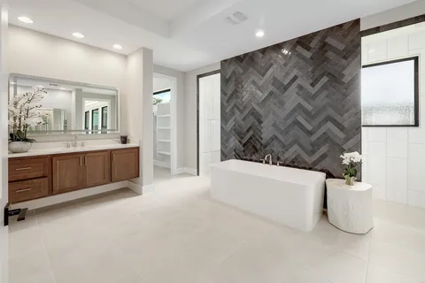 a spacious bathroom with a tub a double vanity sink and a mirror