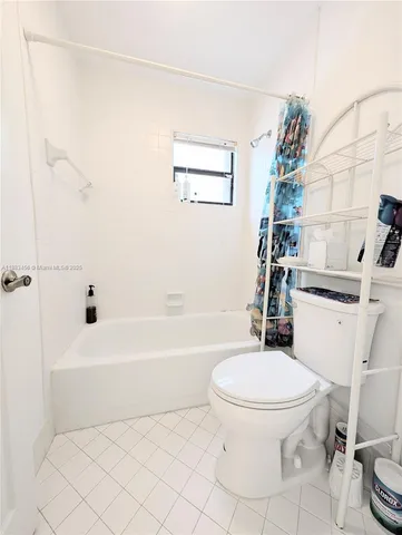 a white toilet sitting next to a white tub