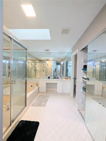 a large en suite bathroom with a tub mirror and double vanity