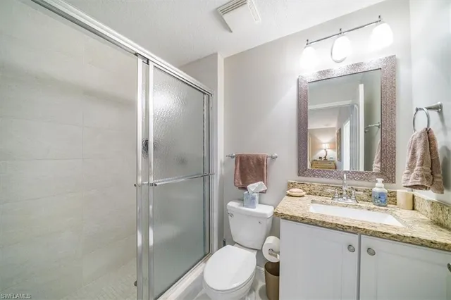 a bathroom with a granite countertop toilet sink and shower