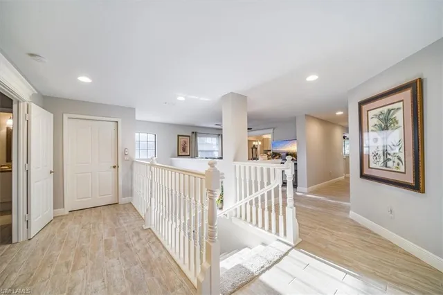 a view of a hallway with wooden floor and windows