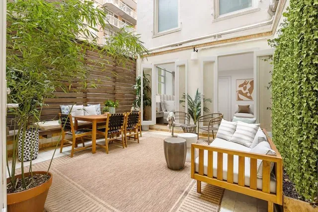 a view of a patio with table and chairs with wooden floor and fence