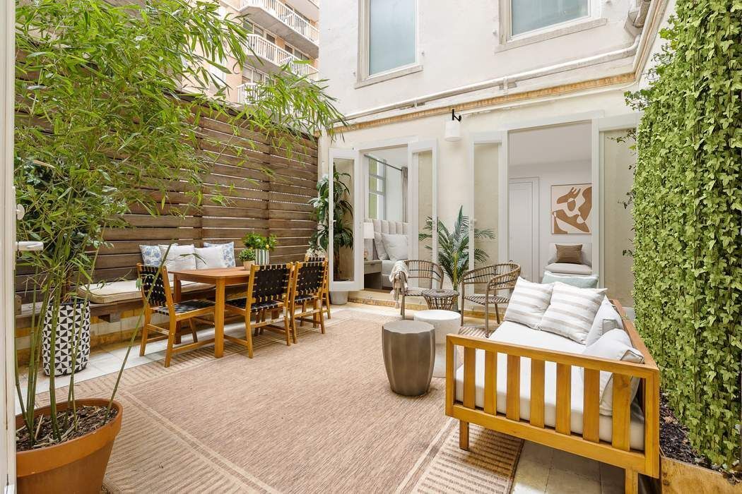 a view of a patio with table and chairs with wooden floor and fence