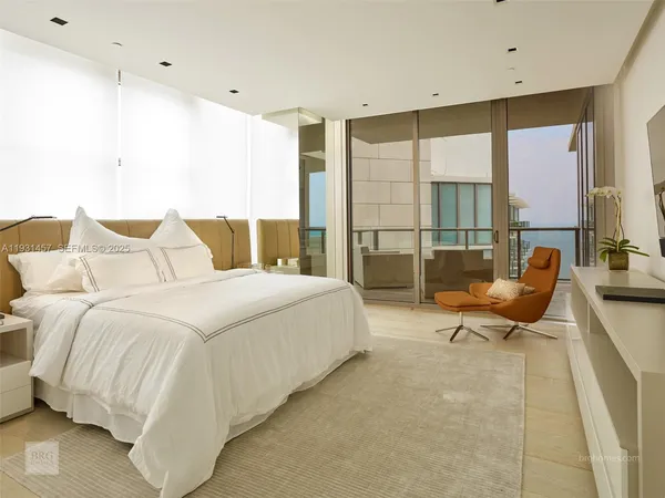 a spacious bedroom with a bed and glass window