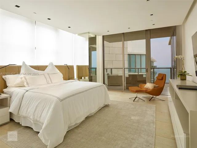 a spacious bedroom with a bed and glass window
