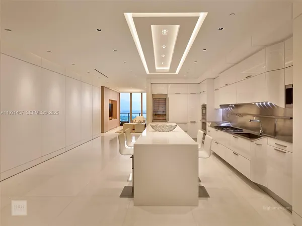 a kitchen with stainless steel appliances granite countertop a sink and a refrigerator