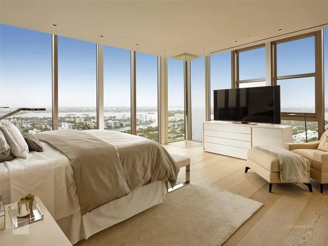 a spacious bedroom with a bed and large window