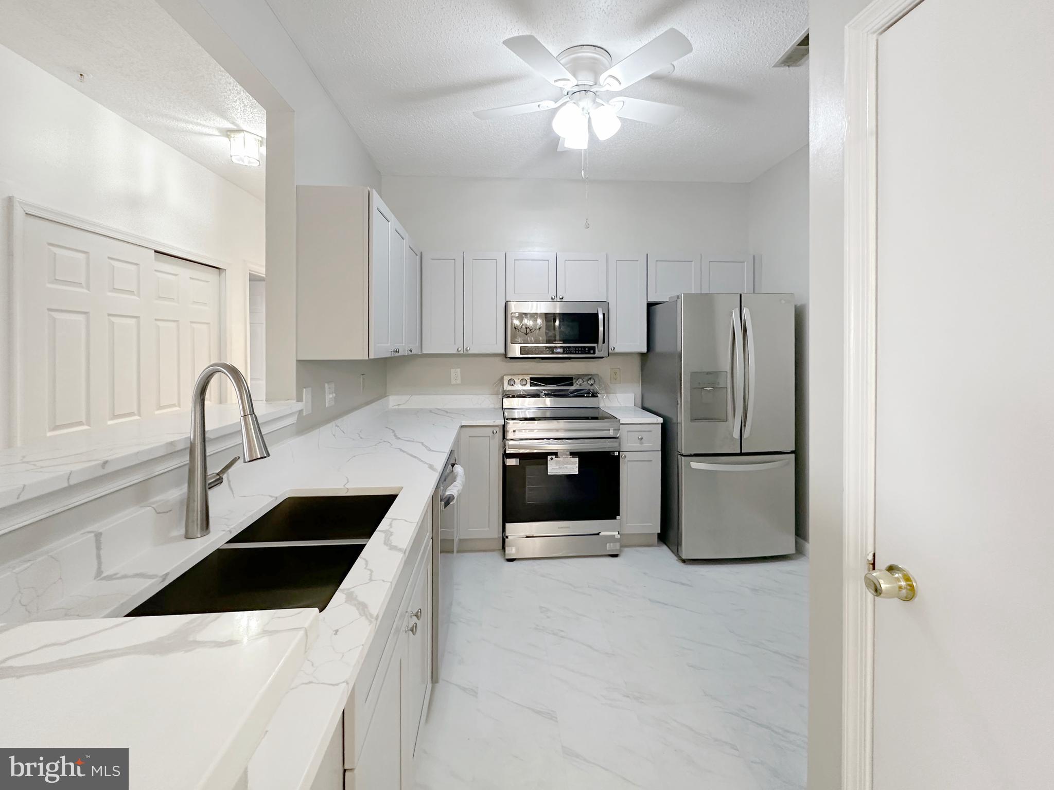 7205 Bogley Road, Unit 202 Baltimore, MD 21244 - Photo 4 of 11 a kitchen with stainless steel appliances a refrigerator sink and white cabinets