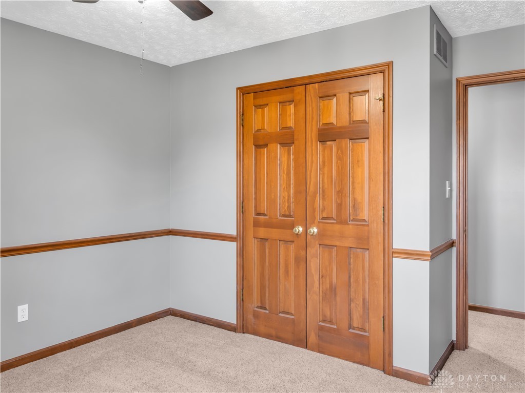 25 Callaway Springboro, OH 45066 - Photo 33 of 51 This cozy bedroom features warm wood trim, a ceiling fan, and plush carpet.
