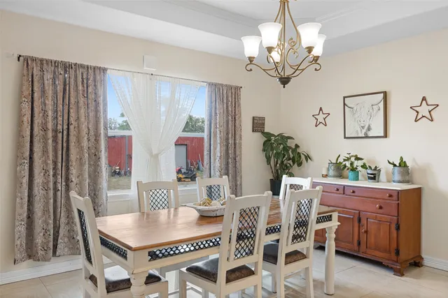 a dining room with furniture a chandelier and window