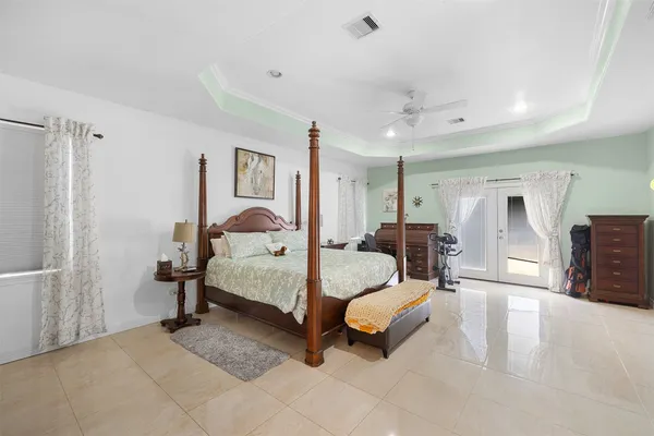 a spacious bedroom with a bed and lamp