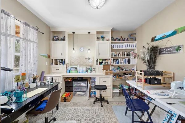 a reading room with furniture a rug and a potted plant