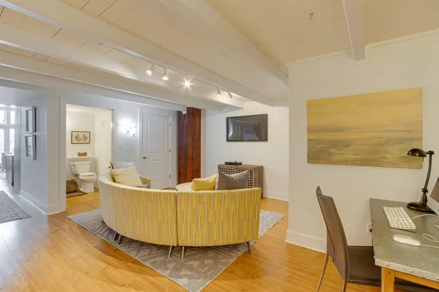 a living room with furniture and a wooden floor