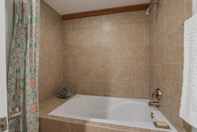 a bath tub sitting next to a blue sink and a shower