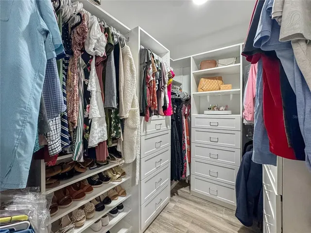 a view of walk in closet with clothes