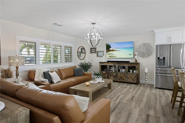 a living room with furniture a dining table and a chandelier