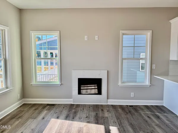 an empty room with windows and fireplace