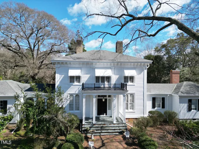 an aerial view of a house with swimming pool and garden