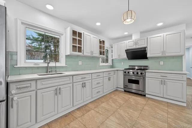 a large kitchen with stainless steel appliances a refrigerator sink and cabinets