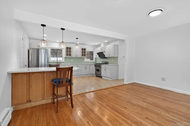 a large kitchen with stainless steel appliances granite countertop a stove a sink and a refrigerator