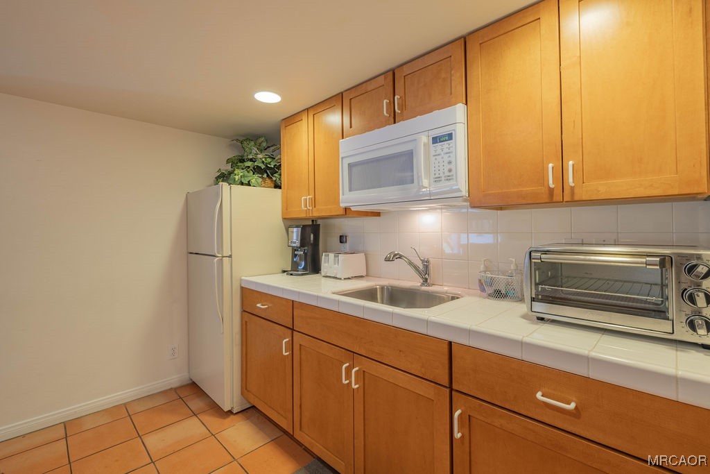 43411 Sheephorn Road Big Bear Lake, CA 92315 - Photo 38 of 50 a kitchen with a sink a refrigerator and cabinets