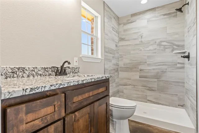 a bathroom with a granite countertop toilet a sink and a bathtub