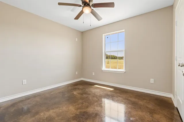 a view of a big room with windows and chandelier fan