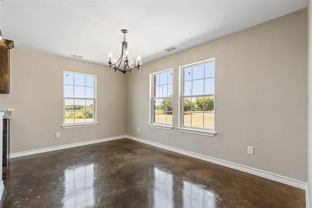 an empty room with windows and chandelier