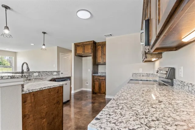 a kitchen with stainless steel appliances granite countertop a sink stove and refrigerator