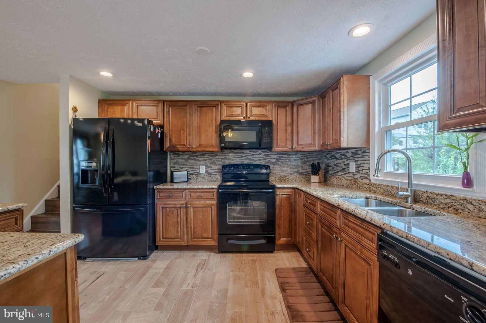 5106 Clifford Road Perry Hall, MD 21128 - Photo 14 of 30 a kitchen with stainless steel appliances granite countertop a stove a sink and a microwave