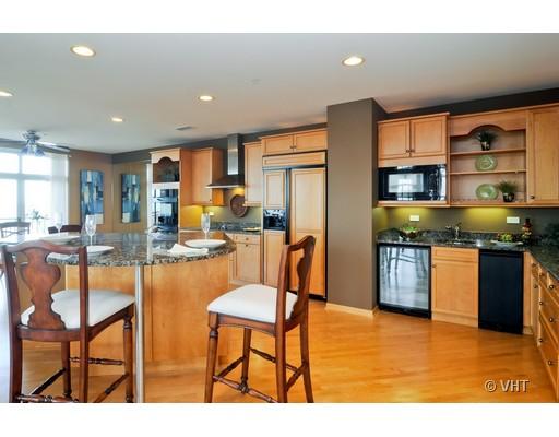3535 Patten Road, Unit 7E Highland Park, IL 60035 - Photo 4 of 14 a kitchen with stainless steel appliances granite countertop a dining table chairs and a refrigerator